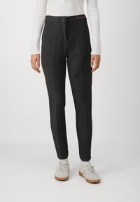 Svarta skräddarsydda byxor med en slät textur, featuring en platt midja och subtila framveck. Accenteras med orange broderi nära midjan.