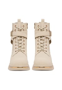 Beżowe sznurowane botki za kostkę z złotymi akcentami, z bocznymi klamrami i teksturowanym materiałem z zamszu, prezentowane z przodu.