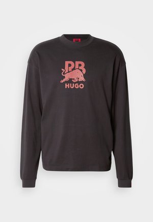 Svart langermet sweatshirt med rund hals. Har en rød grafisk logo med en okse og teksten "HUGO" i midten. Mykt bomullsmateriale.