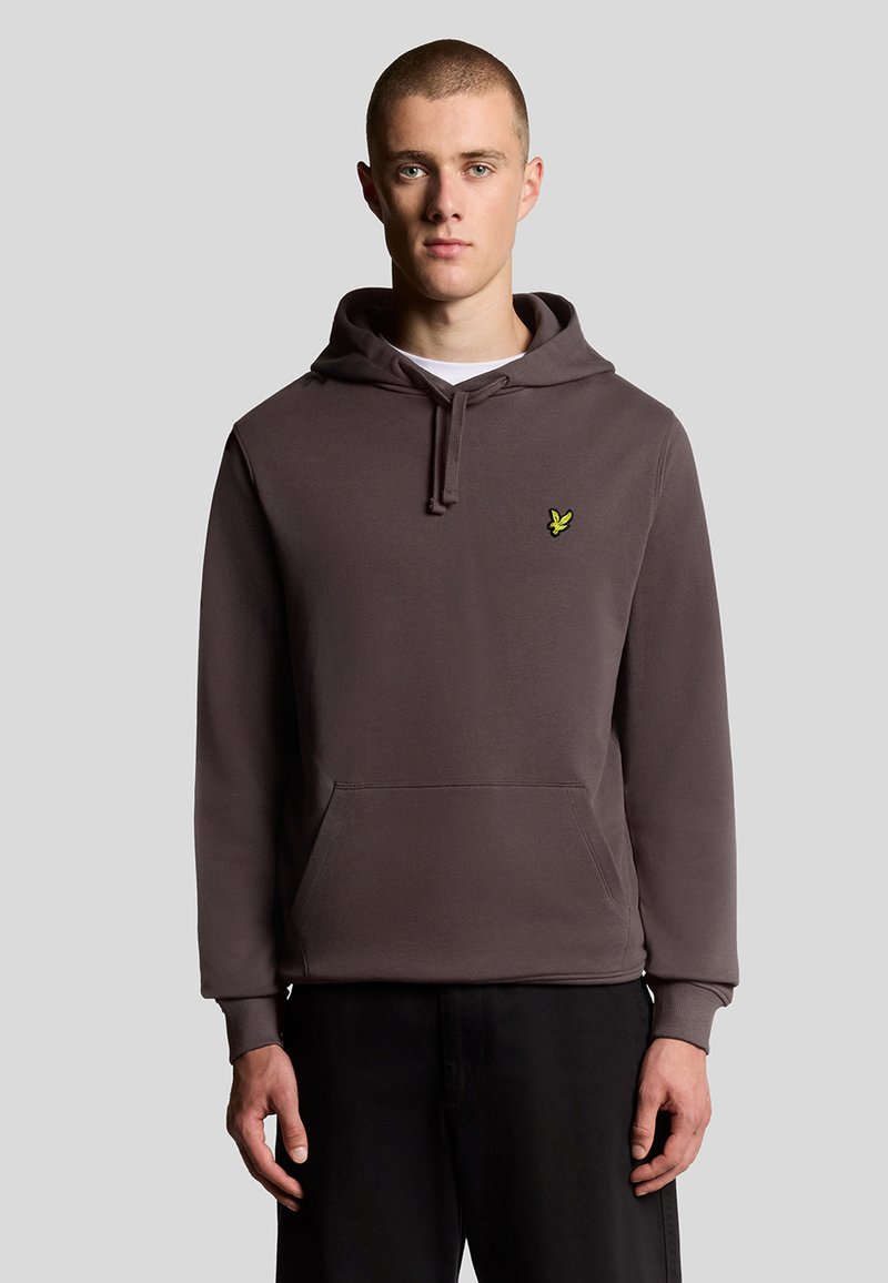 Mørkegrå hoodie lavet af blødt stof, med en kengurulomme og et lille gult logo på venstre bryst. Enkel design med hættesnor.