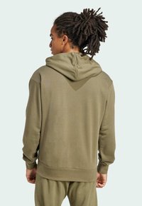 Hoodie i olivgrön. Har en mjuk känsla, avslappnad passform och ribbade muddar och nederkant. Minimalistisk design, inga synliga logotyper.