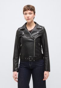 Μαύρο δερμάτινο μπουφάν μοτοσικλετιστή με φερμουάρ σε τσέπες, γιακά με κουμπιά και ζώνη στη μέση. Διαθέτει ασημένια μεταλλικά στοιχεία και λεία υφή.