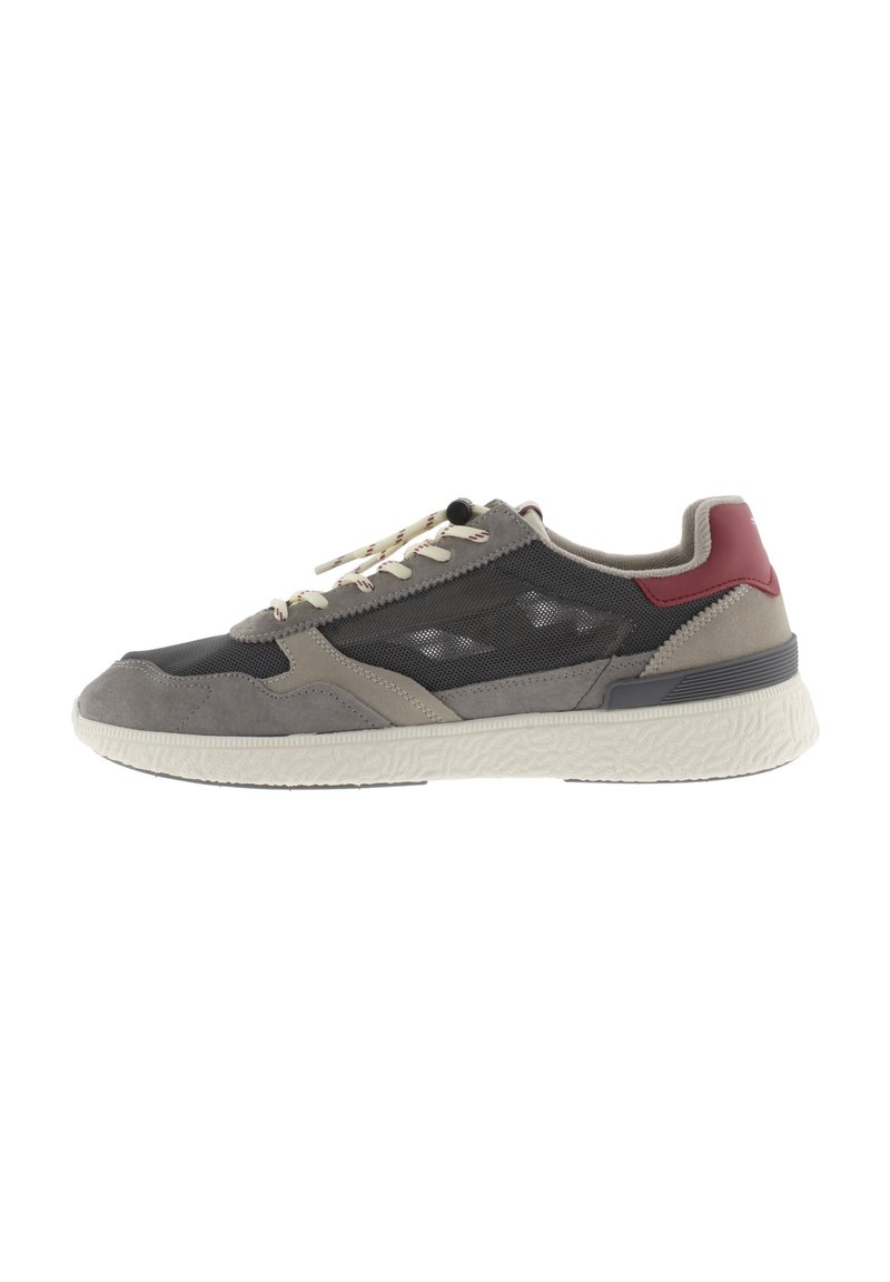 Scarpa atletica grigia e beige con pannelli in rete, accenti rossi a contrasto, suola bianca piatta e lacci crema. Dettagli testurizzati sulla suola.