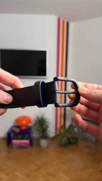 Cintura in pelle nera con un accento blu, dotata di una fibbia in metallo opaco. Presenta due punte e una texture liscia. Nessun motivo o dettaglio di ferramenta visibile.