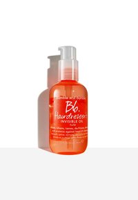 Bouteille en plastique orange avec un distributeur à pompe transparent. L'étiquette présente un texte blanc indiquant "Huile Invisible de Coiffeur" et ses bienfaits pour les cheveux.