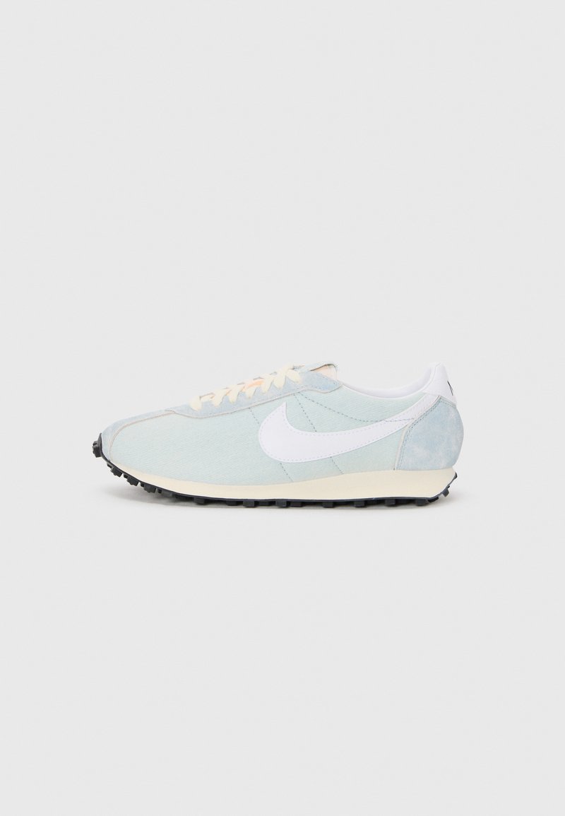 Lyseblå atletiksko med en hvid swoosh, tekstureret stof, cremefarvede detaljer og en sort gummisål. Har snøresystem.
