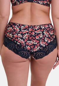Culotte à imprimé floral marine avec des fleurs roses et blanches. Présente un bord en dentelle noire contrastante le long des bords, avec un design festonné.