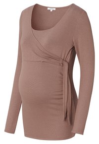 Graviditetsbluse i blødt brunt stof med vrap-design, lange ærmer, sidetasker og indsnævringer i siderne for øget komfort og justerbarhed.