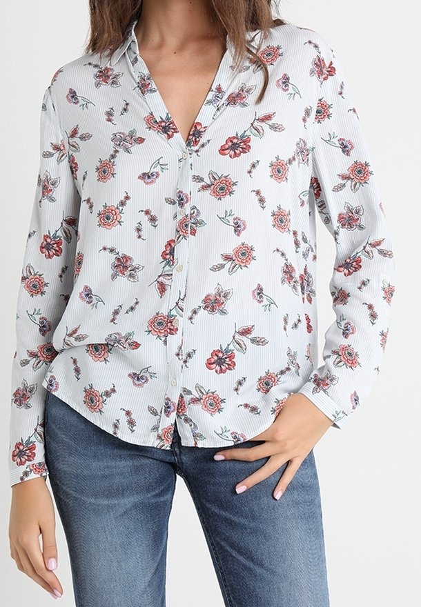 Chemise à boutons en tissu léger, avec un imprimé floral rouge et vert sur un fond rayé clair. Manches longues et coupe décontractée.