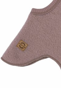 Palton pentru câine din fleece, de culoare roz prăfuit, cu o formă rotunjită, guler elastic, margini cusute și o etichetă din material textil maro cu un logo.