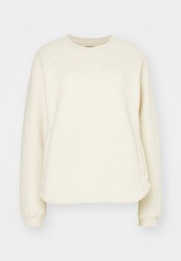 Felpa in pile di colore crema con maniche lunghe a raglan, scollatura rotonda e tasche laterali. Texture morbida con orlo curvo.