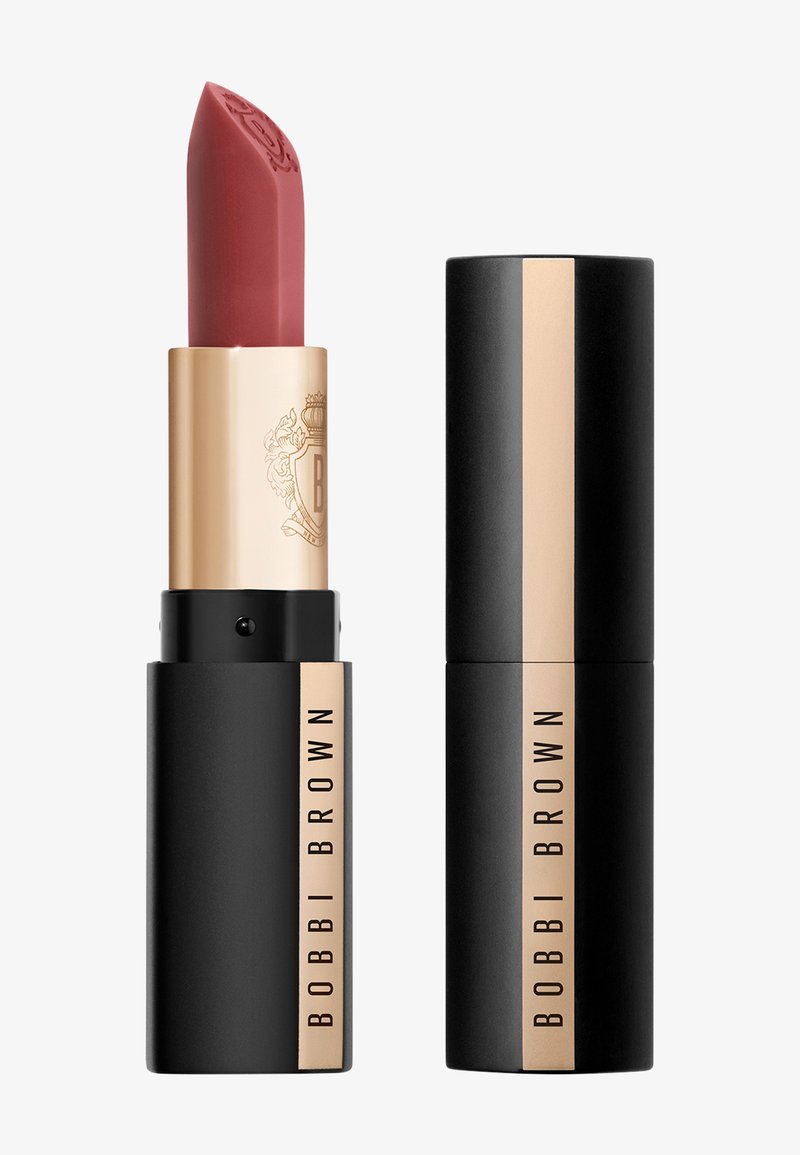 Bobbi Brown leppestift i et metallisk gull- og svartetui. Kappen er i en myk rosa nyanse med et detaljerte logo på toppen. Glatt tekstur.