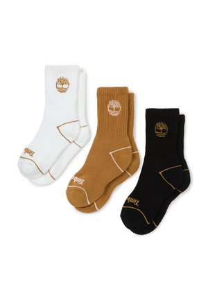 Drie paar crew-sokken in wit, bruin en zwart, elk met een boomlogo bij de boord en contrasterende stiksels op een witte achtergrond.