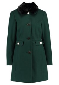 Cappotto verde scuro in tessuto texturato, con colletto in pelliccia sintetica nera, cinque bottoni e due tasche frontali con alette decorative.