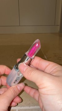 Rossetto KIKO con tubetto trasparente e dettagli in argento metallizzato. Il bullet è di colore rosa scintillante, con punta arrotondata.
