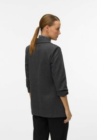 Grå rutet jakke med en skræddersyet design, der har krave, trekvartærmer og en glat tekstur. Synlige sidesømme og manchetter.