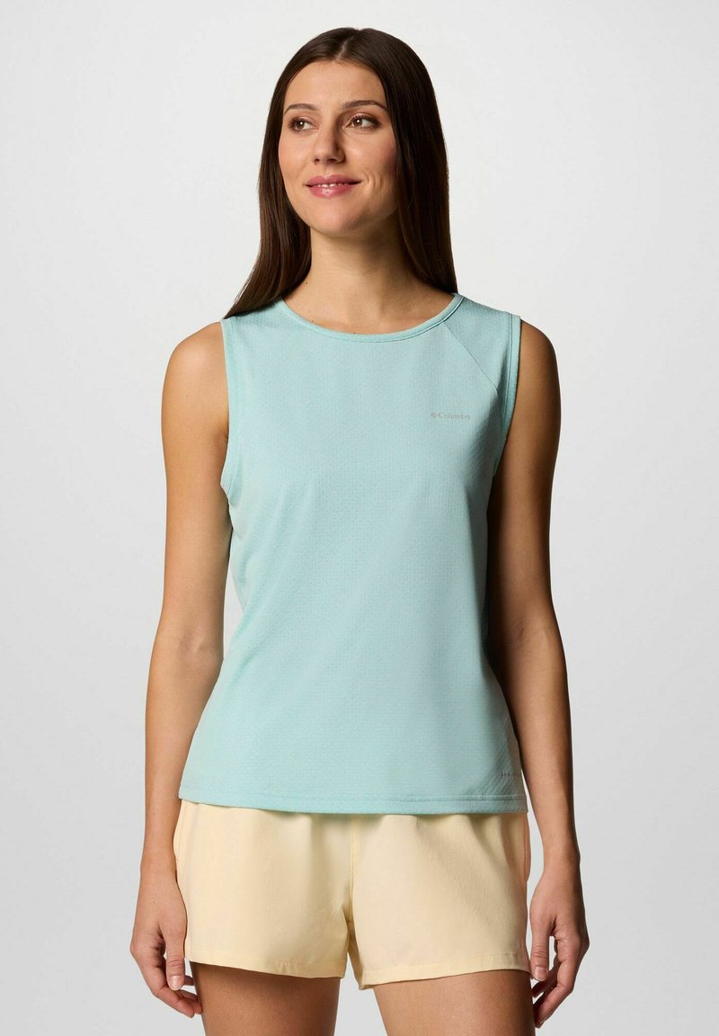 Top atletico senza maniche di colore azzurro chiaro con scollo rotondo, tessuto testurizzato e logo del marchio discreto. Abbinato a pantaloni corti giallo chiaro.