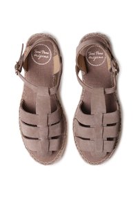 Sandalias de ante marrón con un diseño trenzado, correa ajustable con hebilla y suela tipo espadrille cosida. Interior de tejido texturizado.