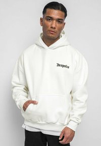 Hoodie blanc avec poche avant et poignets côtelés. Logo "Dropsize" noir brodé sur la poitrine gauche. Texture douce et coupe décontractée.