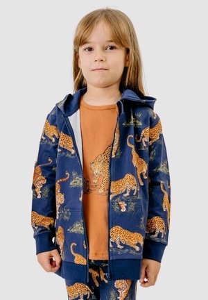 Child wearing a navy blue hoodie, pants, and orange shirt with matching leopard and tiger animal prints on a plain background.