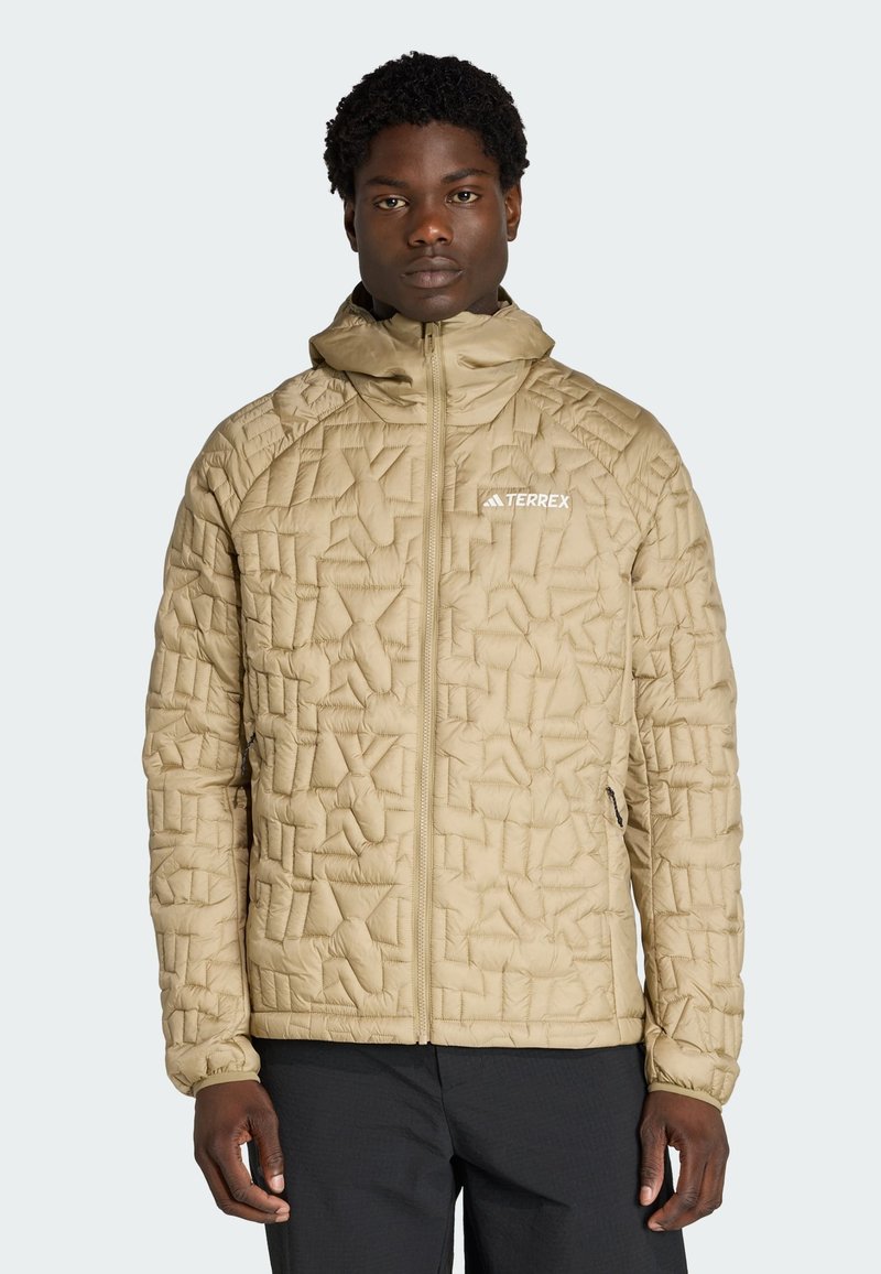 Beige isolierte Jacke mit geometrischem Steppmuster, durchgehendem Reißverschluss und Kapuze. Verfügt über ein kleines Logo und elastische Bündchen.