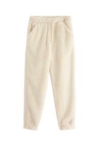 Pantaloni jogger in pile color crema con elastico in vita, cordino, tasche laterali e gambe affusolate.