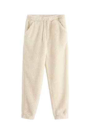 Pantaloni jogger in pile color crema con elastico in vita, cordino, tasche laterali e gambe affusolate.