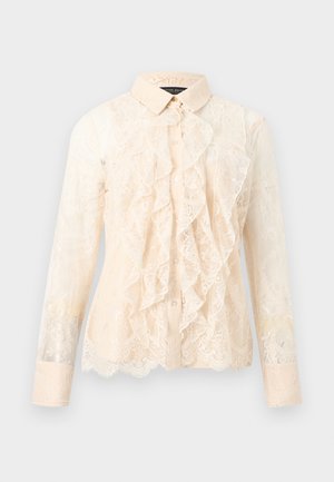 Μπεζ μακρυμάνικο μπλουζάκι από δαντέλα με βολάν εμπρός, κλείσιμο με κουμπιά και κλασικό γιακά, σε απλό φόντο.