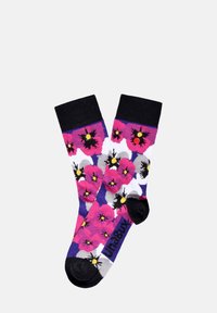 Farverige sokker med et blomsterdesign i pink, lilla og grå blomster. Sorte manchetter og tådetaljer. Mærkenavnet er synligt på siden.