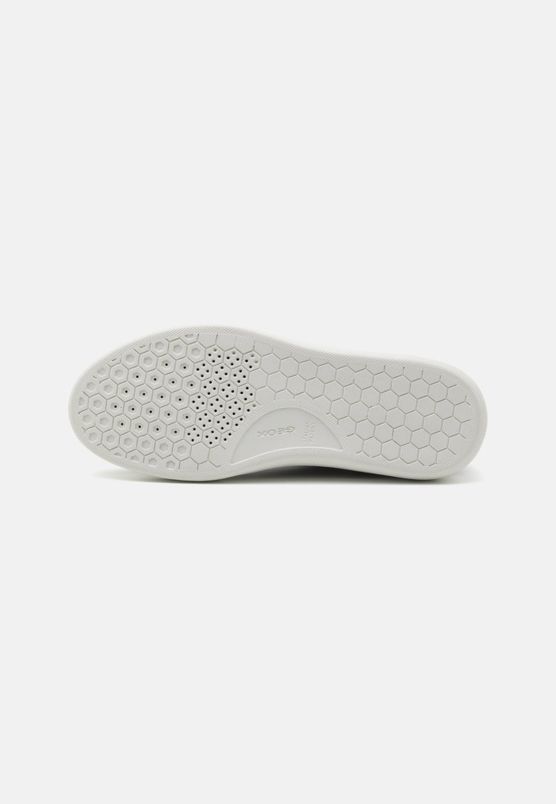 Semelle de sneaker blanche avec une surface texturée présentant un motif en nid d'abeille et de petites perforations pour la ventilation. Forme de bout rectangulaire.