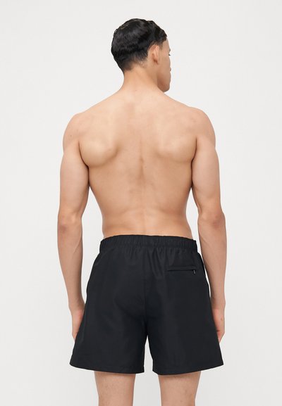 Shorts de bain noirs en tissu léger avec une taille élastique et une poche arrière. Le design est simple et fonctionnel.