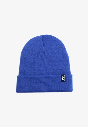Blauwe beanie muts van gebreid materiaal, met een opgerolde rand en een klein zwart label met een wit logo aan de zijkant.