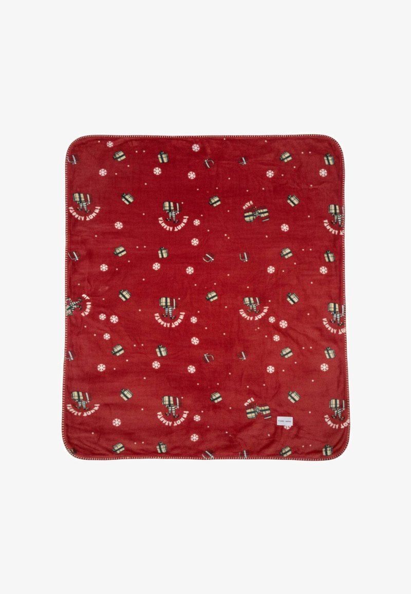 Manta de forro polar roja con un patrón de regalos y copos de nieve. Borde acabado con costura decorativa. Textura suave.