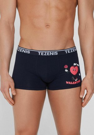 Boxer- Shorts bleu foncé avec une taille blanche sur laquelle est inscrit le texte "TEZENIS". Le design inclut un cœur graphique et une rose avec le texte "SOIS MON VALENTIN".