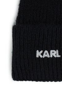 Gorro de punto negro con textura acanalada y un dobladillo, con el logotipo bordado en plata "KARL" en la parte frontal.