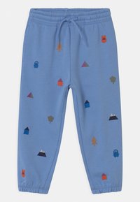 Pantalones de chándal de color azul claro con cintura elástica, que presentan coloridos bordados de árboles, casas, formas y un fantasma.