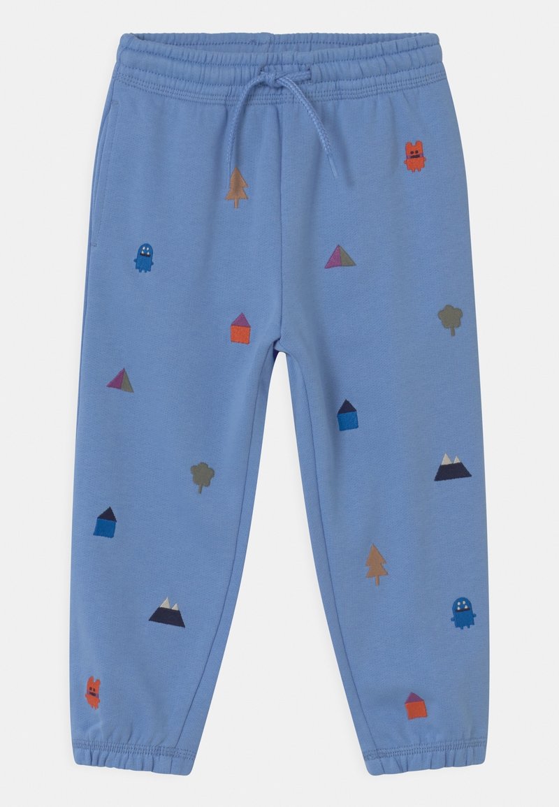 Ljusblå träningsbyxor med elastisk midja, prydda med färgglada broderade mönster av träd, hus, former och ett spöke.