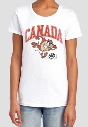 Person wearing a white t-shirt with "CANADA" text and a cartoon character playing soccer printed on the front.