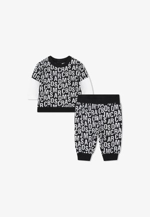 Bawełniany zestaw składający się z czarno-białej bluzki z długim rękawem z wyraźnym napisem oraz dopasowanych spodni, obie części z żeberkowymi mankietami i pasem.