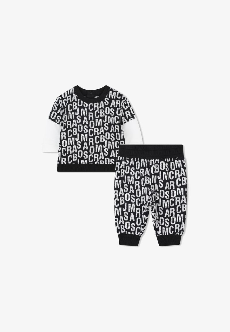 Katoenen outfit met een zwart-wit langemouwen top met bold letters en bijpassende broek, beide met ribbels aan de mouwen en de taille.