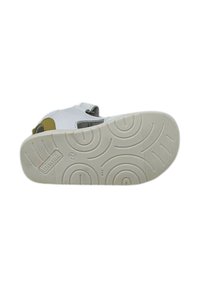 Sandal bianca con suola in crema testurizzata, dotata di un accento giallo e cinturino regolabile. Il design presenta ritagli per la traspirabilità.