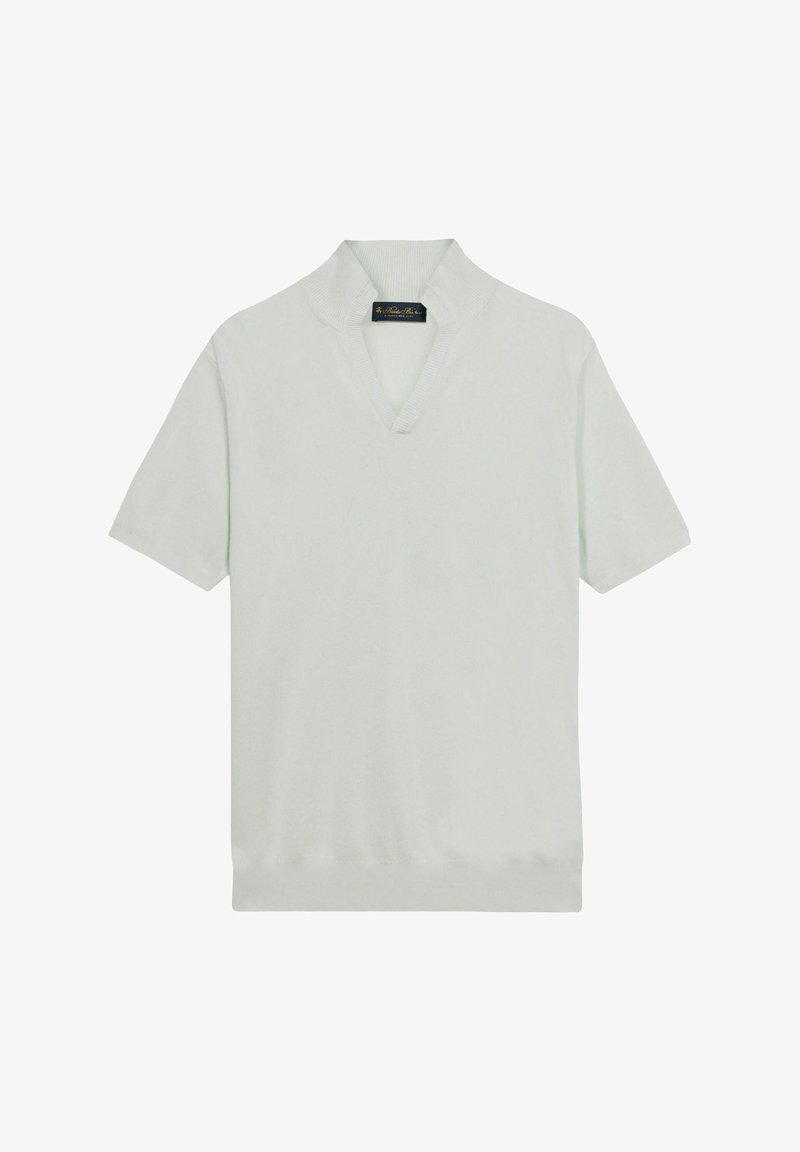 Chemise tricotée blanche à manches courtes avec un col châle côtelé et une ouverture en V, posée à plat sur un fond blanc.