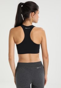 Black sports bra with a racerback design, made from stretchy fabric. Gray leggings with an elastic waistband, featuring "ONLY PLAY" logo.