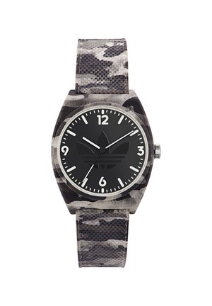 Montre noire camouflage avec un bracelet texturé, matériel en acier inoxydable argenté et un cadran rond noir avec des index horaires blancs et un logo au centre.