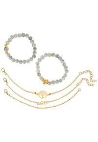 Deux bracelets élastiques avec des perles en marbre gris, l'un d'eux comportant un accent en or. Trois chaînes en or incluent un pendentif arbre de vie et un charme ancre.