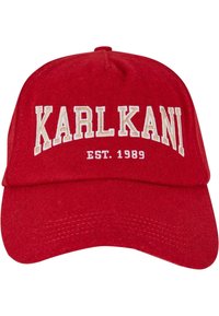 Piros baseball sapka, textilből készült, lekerekített koronával és ívelt csúccsal. Fehér hímzett szöveg található rajta: "KARL KANI" és "EST. 1989."