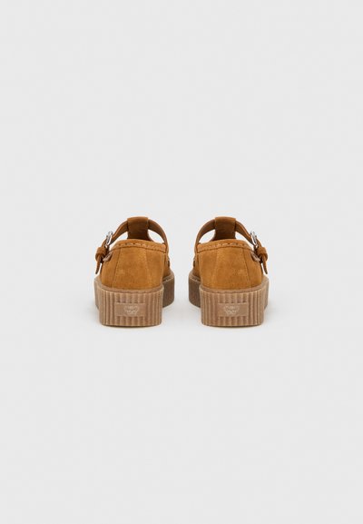 Sandales en daim marron avec un bout arrondi, une bride arrière et une semelle en liège nervurée. Comportent une boucle métallique en détail sur la bride.