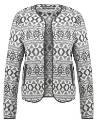 Veste à manches longues, à ouverture devant, avec des motifs tribaux géométriques noirs et blancs et une bordure noire unie autour des bords et des poches.