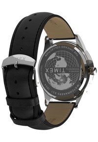 Timex-klocka med svart läderarmband, klockhus i rostfritt stål och en globdesign på baksidan. Vattentålig ner till 50 meter.