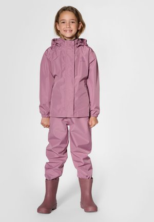 Lyserød vandtæt jakke med matchende bukser, har en hætte, elastiske manchetter, glat tekstur og robuste gummistøvler i en mørkere lyserød nuance.
